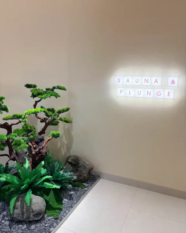 Sauna & Plunge sign beside a bonsai