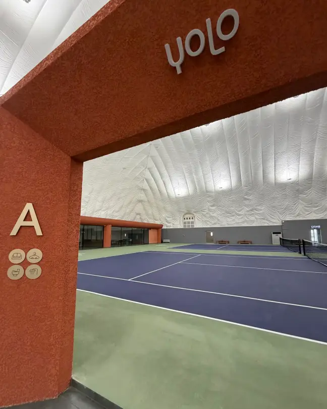 Terracotta arch opening onto tennis court A